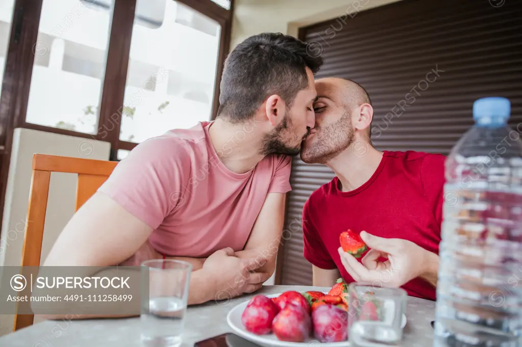 Gay couple eating strawberries