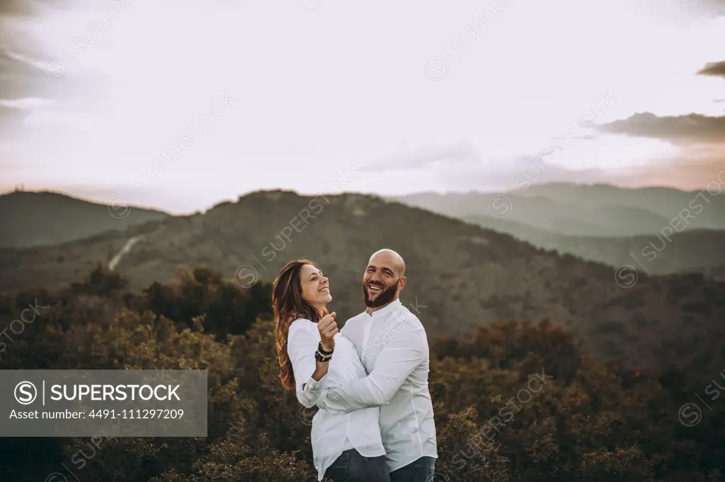 Affectionate couple having fun on hilly valley