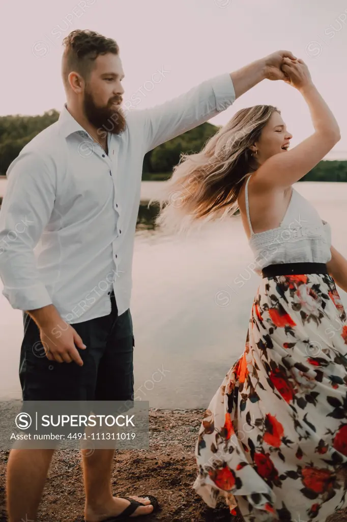 Loving couple standing ankle deep in water on beach 