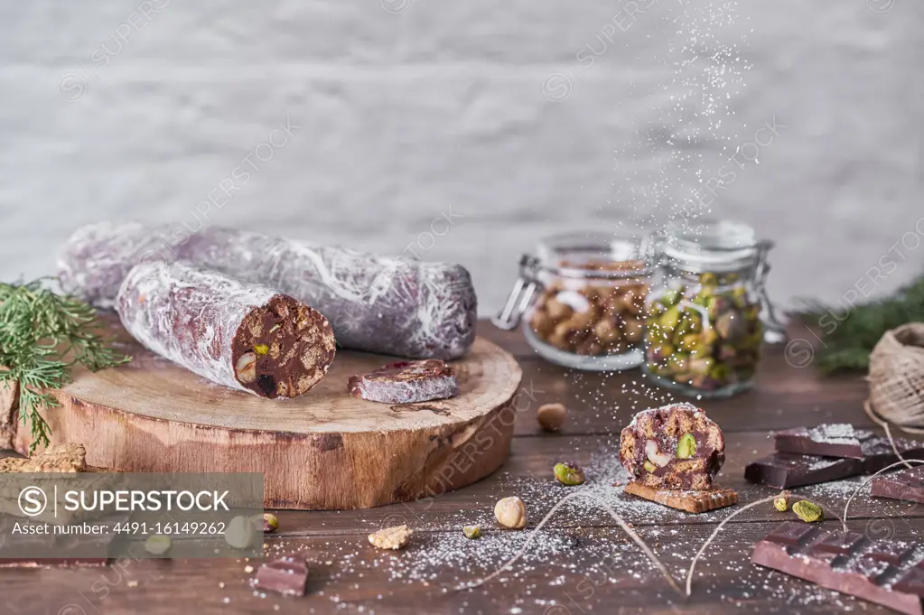 Chocolate salami with nuts on wooden table