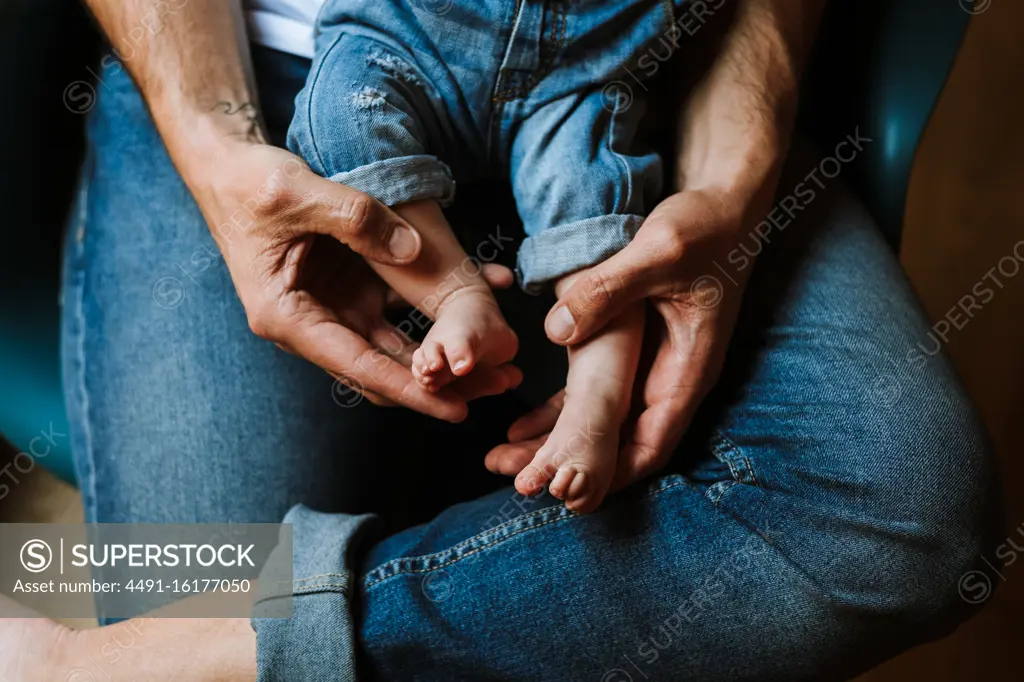 Crop parent with baby resting at home