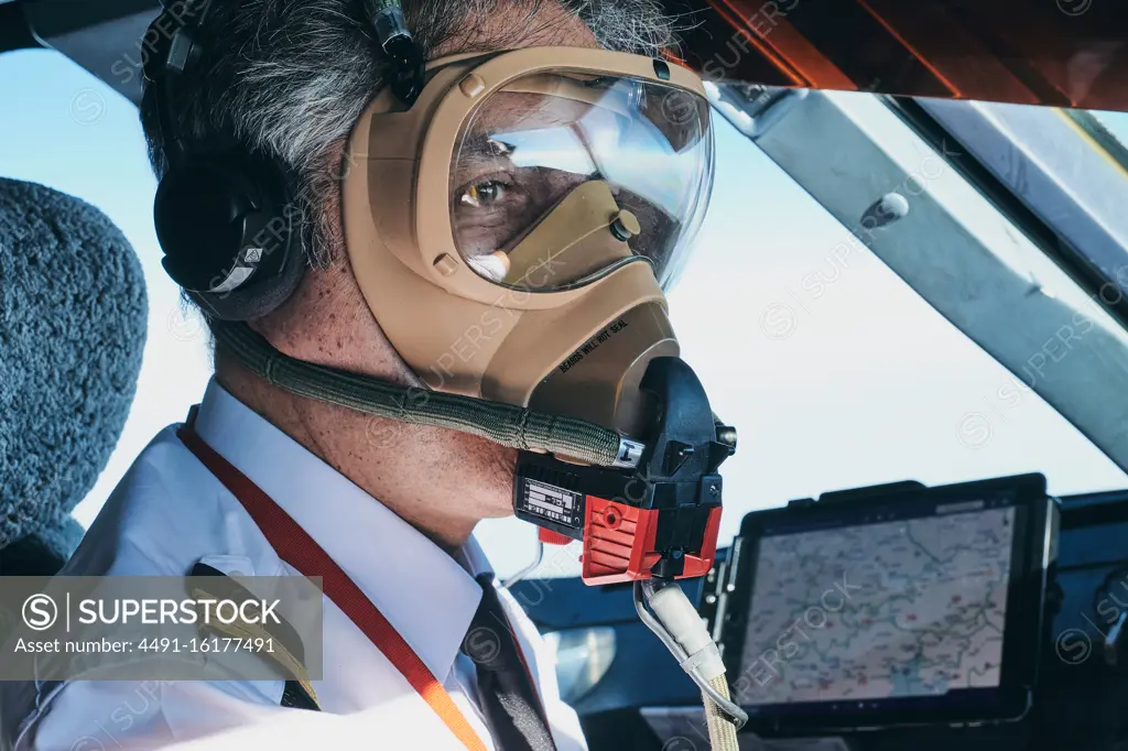 Pilot in mask operating airplane during flight