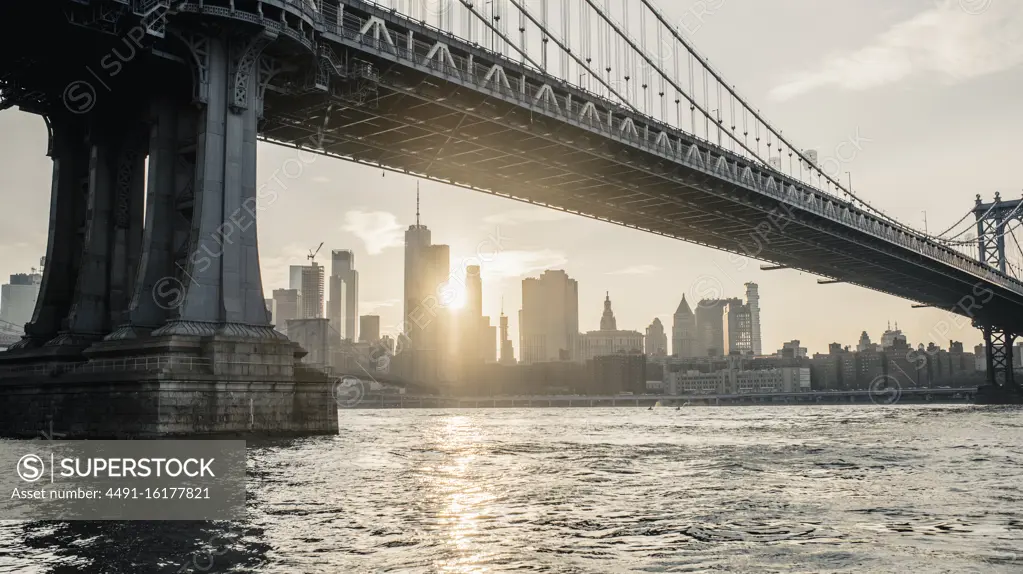 Modern cityscape with bridge over river in evening