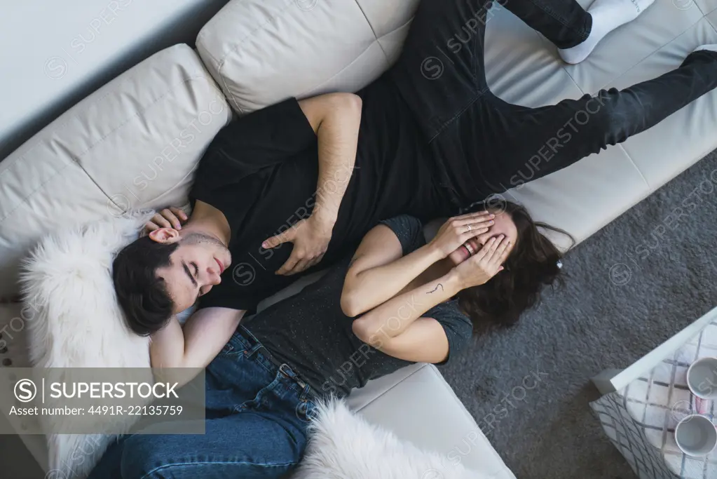 Couple lying on sofa