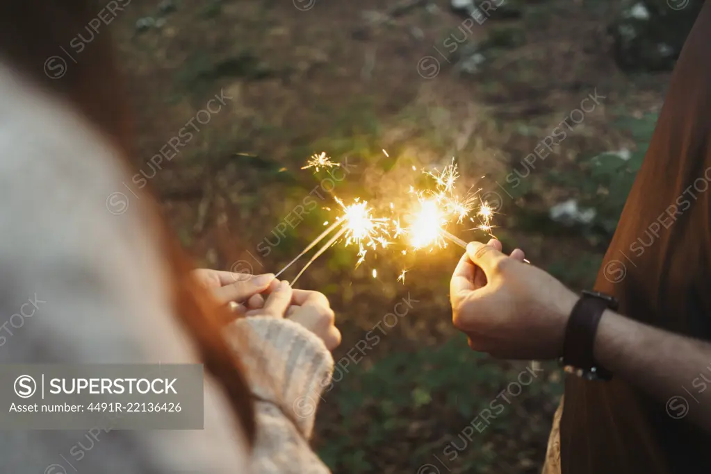 Hands with sparklers in woods