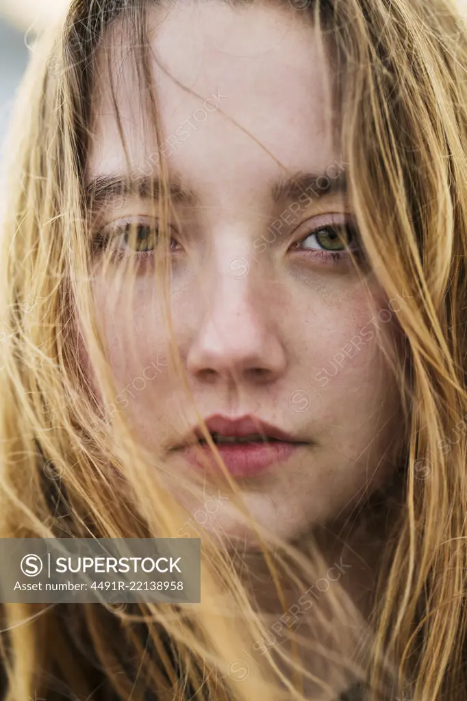 Vertical close-up portrait of young girl with flying hair.