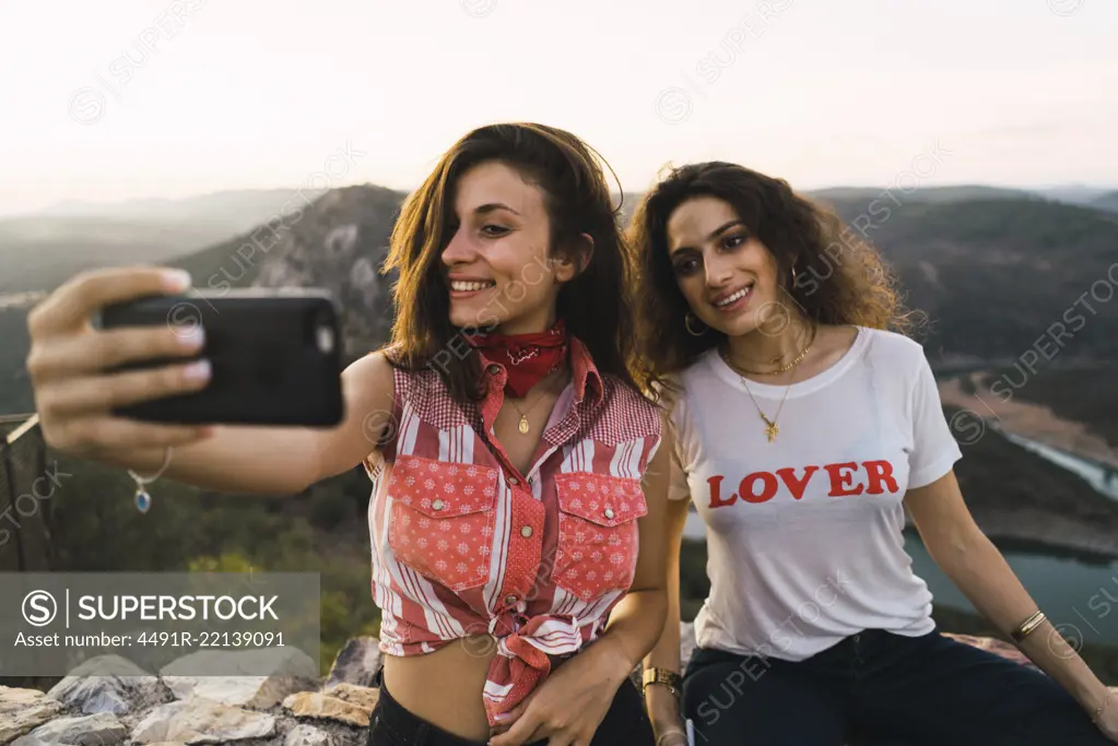 Stylish women taking selfie on breathtaking landscape