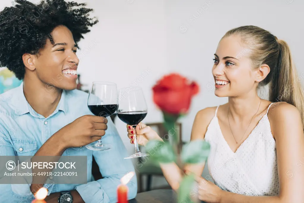 Happy young in love interracial couple having romantic dinner on valentines day at home 