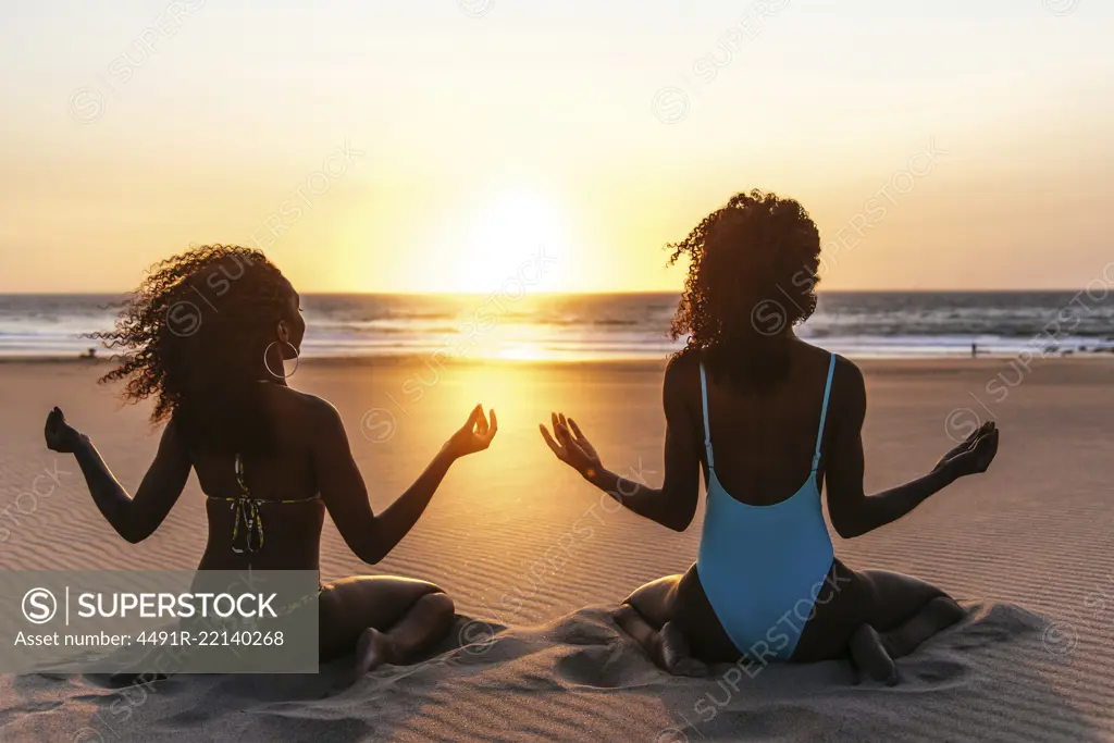 Content models on tropical beach in sunset