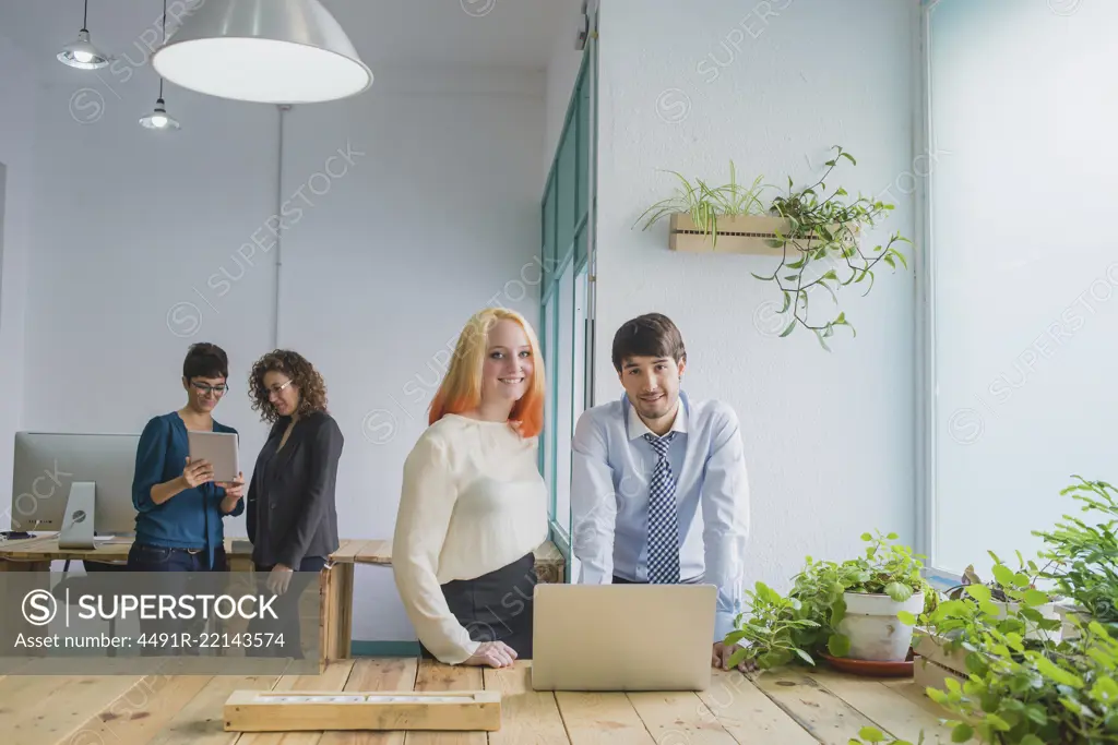 Four young smiling businessmen working