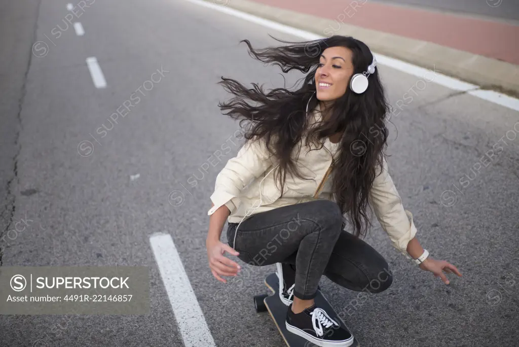 Young girl having fun in the street with longboard