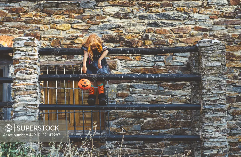 Kid in costume posing on fence