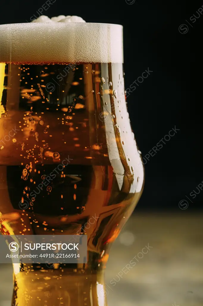 Glass of cold beer on dark background