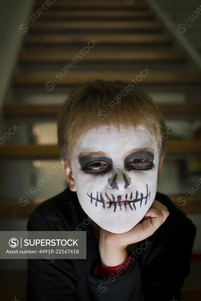 Boy with face painted like a skull