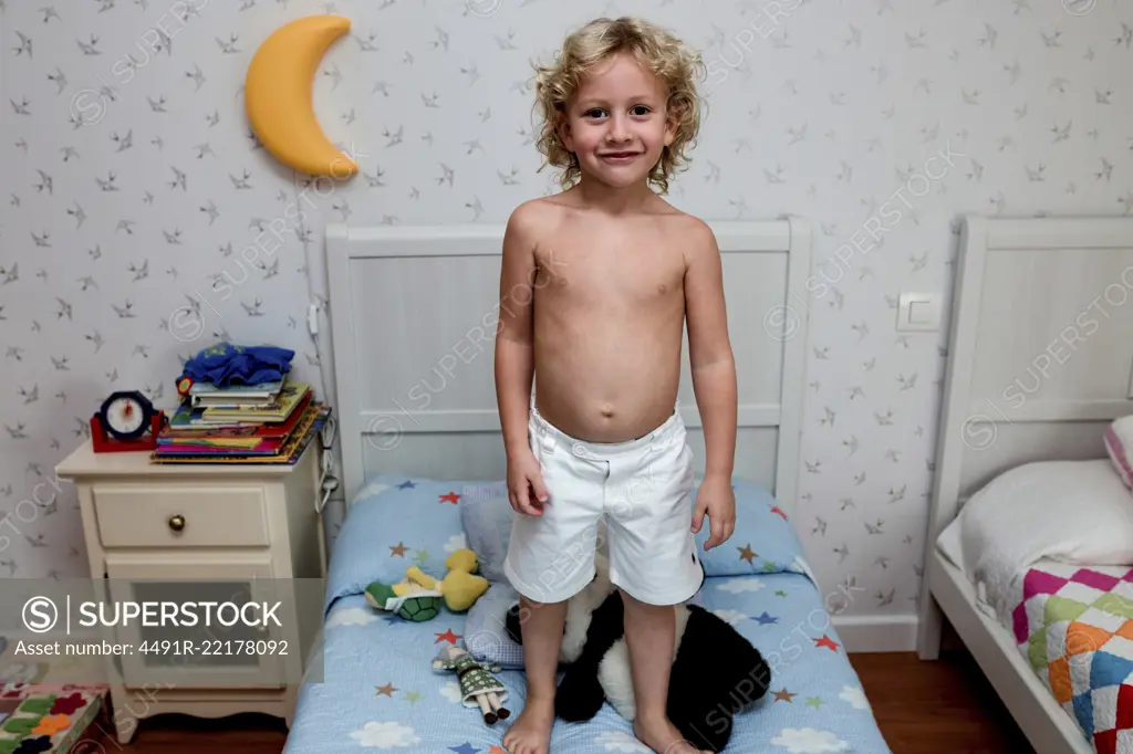 Boy standing in bed