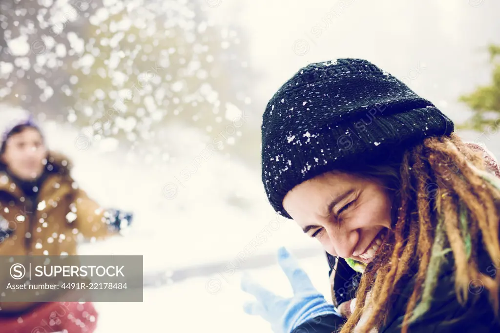 Friends playing snowballs in woods