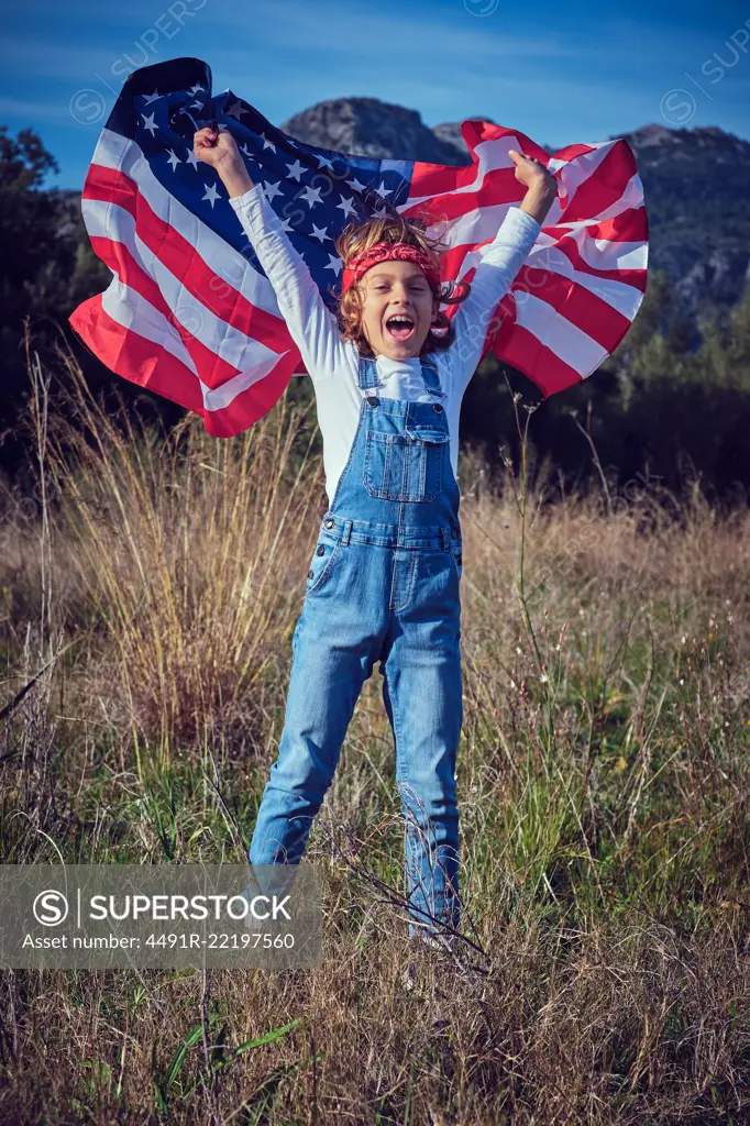 Boy in nature holding an American flag