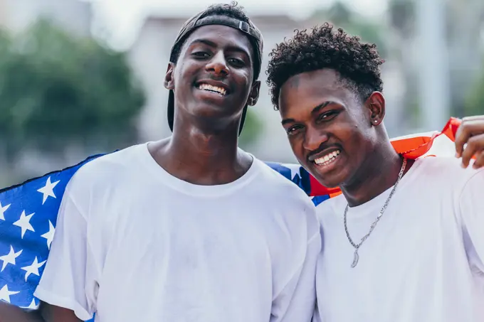 African American men holding American flag on shoulder and looking away