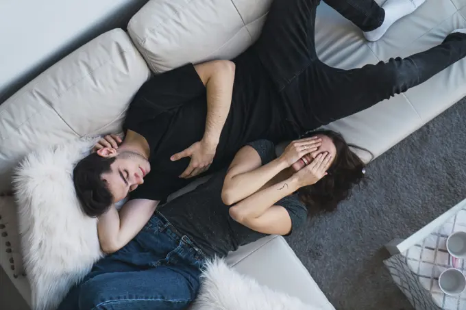 Couple lying on sofa