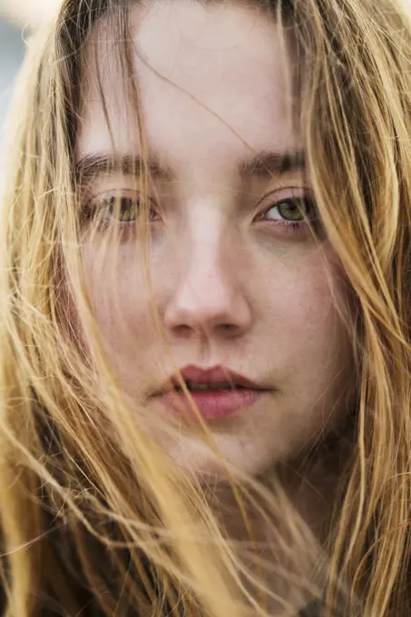 Vertical close-up portrait of young girl with flying hair.