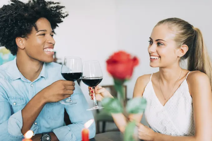 Happy young in love interracial couple having romantic dinner on valentines day at home 