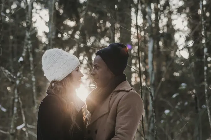 Multiracial couple bonding in winter forest