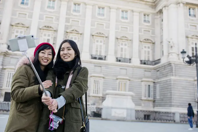 Asian women taking selfie on street