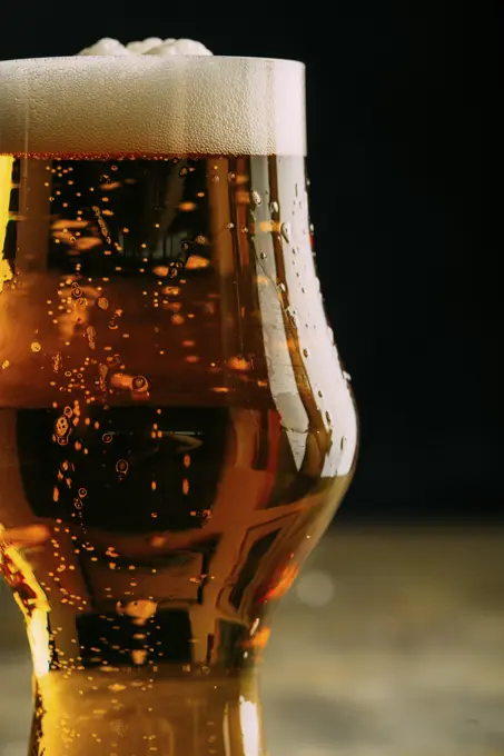 Glass of cold beer on dark background