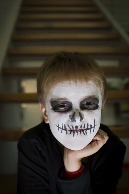 Boy with face painted like a skull