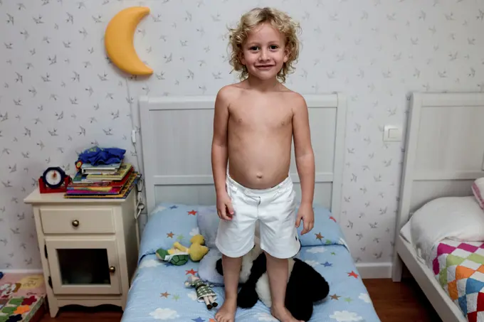 Boy standing in bed