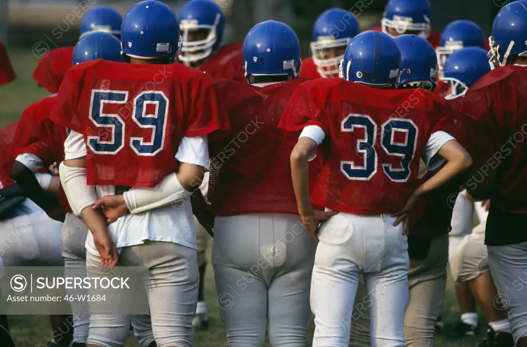 Football players discussing in playground, Stuyvesant High School, New York City, New York State, USA