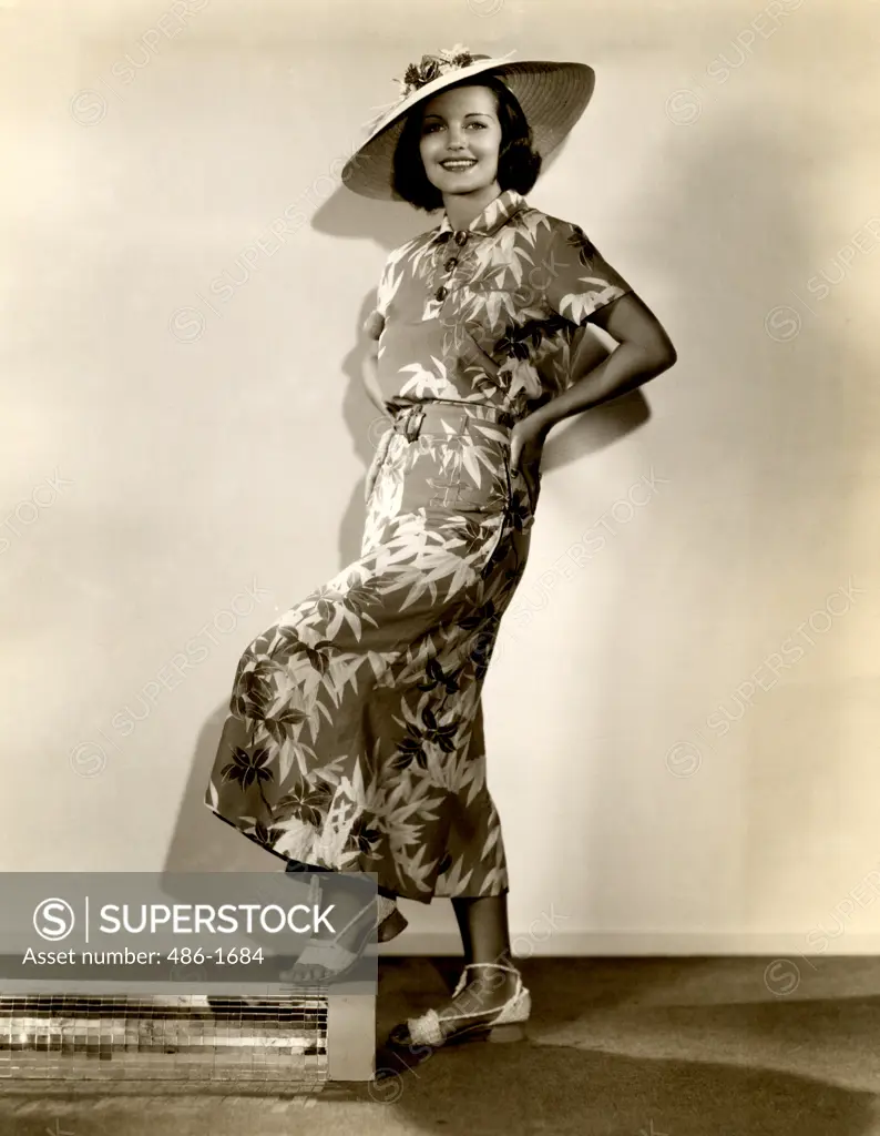 Studio shot of young woman in straw hat and dress