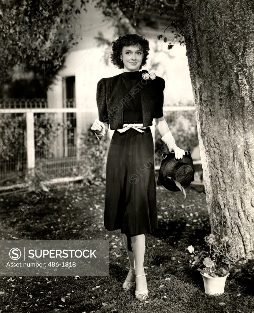 Young woman posing in elegant clothing in domestic garden