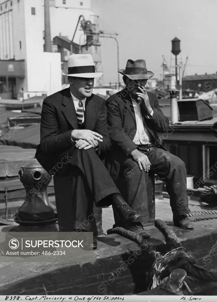 USA, New York City, Two Men Sitting In Harbor