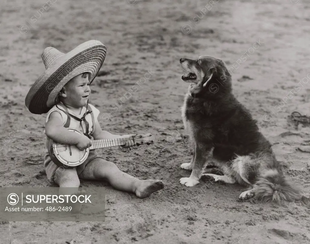 Boy with toy guitar playing song to furry dog