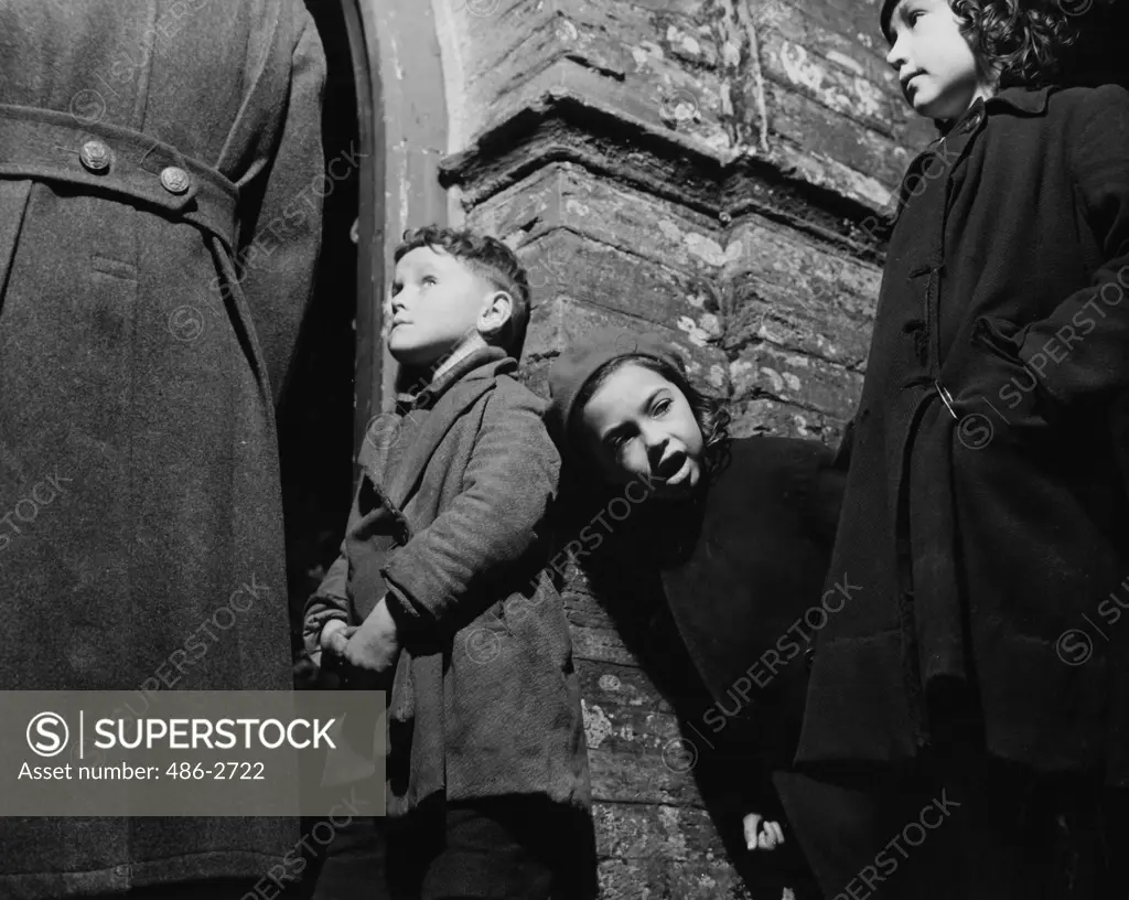 Children and man standing by building