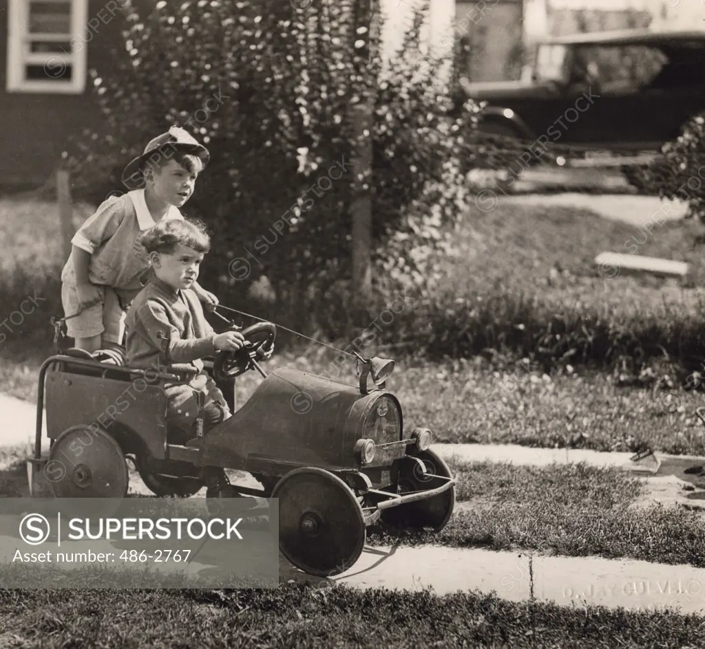 Two boys playing with toy car