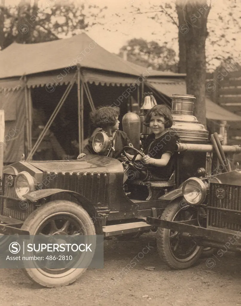 Portrait of girl sitting in toy car