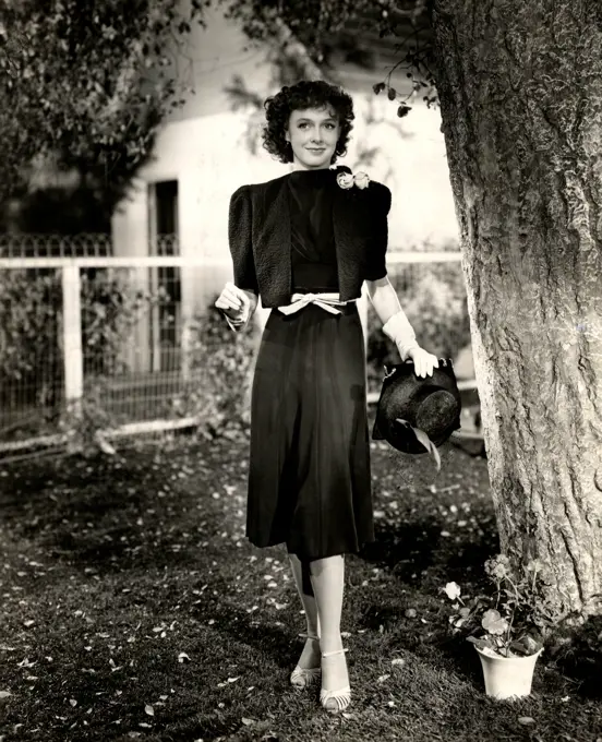 Young woman posing in elegant clothing in domestic garden