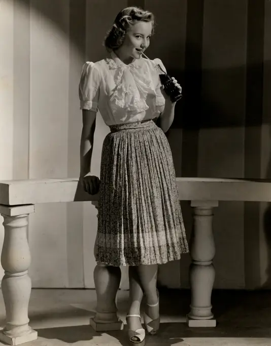 Studio shot of fashion model in casual clothing drinking soda