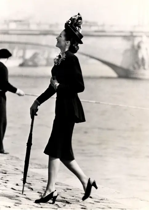 Mid adult woman walking on riverbank in elegant clothing