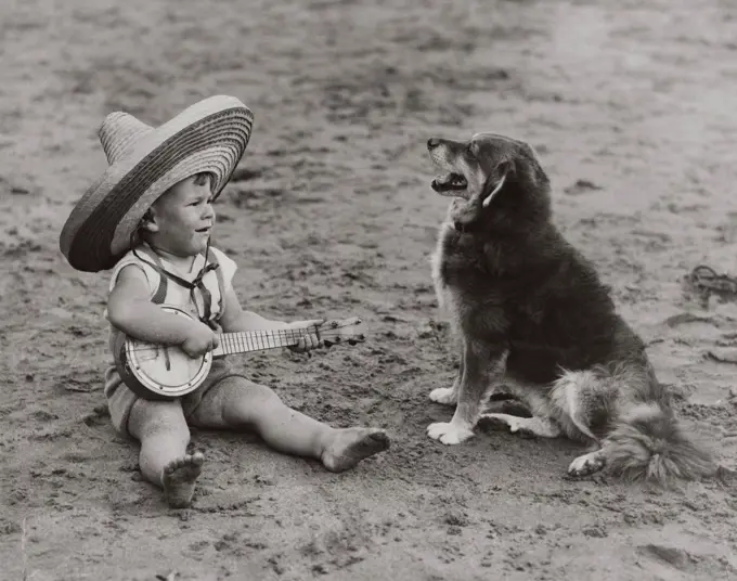 Boy with toy guitar playing song to furry dog