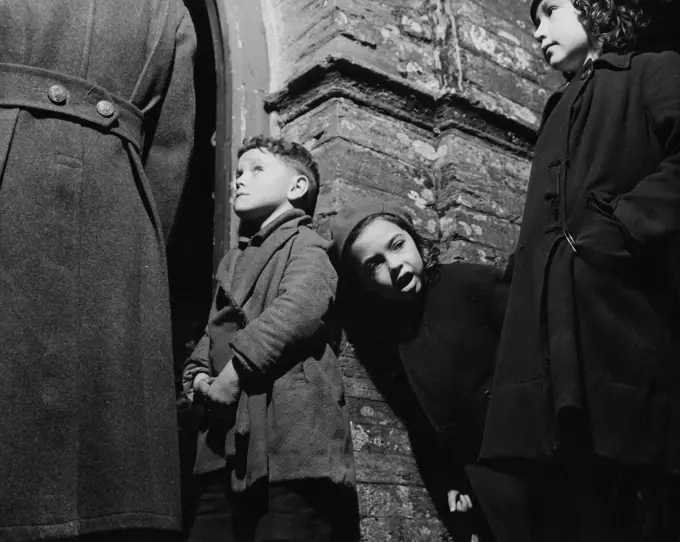 Children and man standing by building