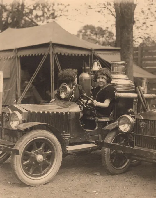 Portrait of girl sitting in toy car