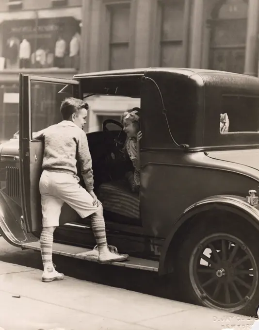 Portrait of girl inside car and boy standing outside