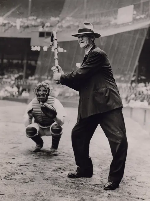 Senior man wearing full suit playing baseball with his walking stick