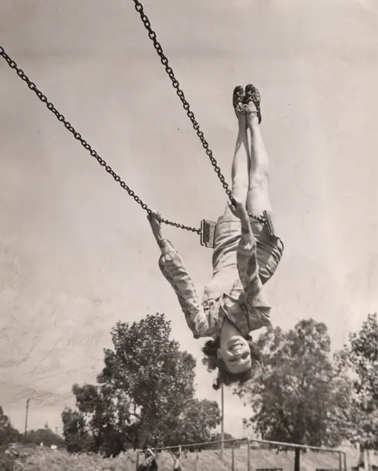 Julie Bishop, who has just completed the feminine lead opposite Errol Flynn in Warner Bros. Northern Pursuit, likes to get her exercise on good old fashioned swings