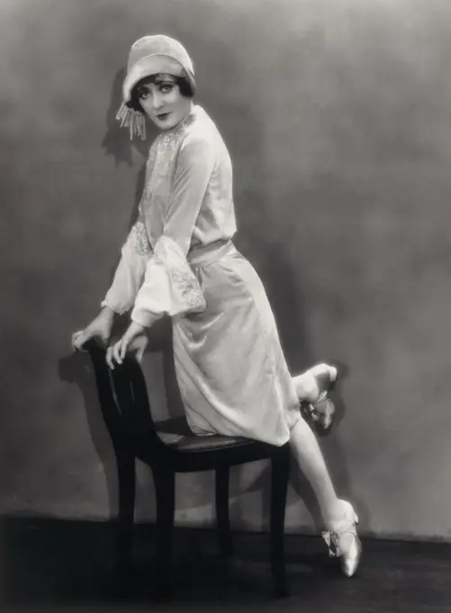 Portrait of a young woman leaning on a chair