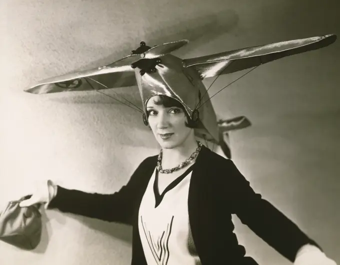 Close-up of a young woman wearing an airplane on her head