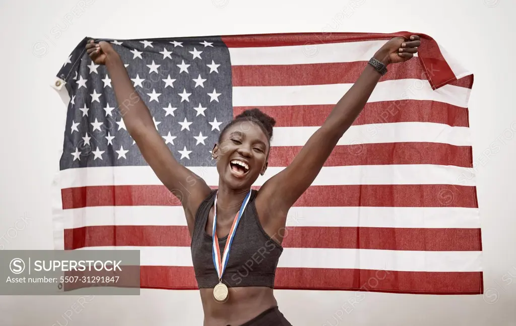 You can congratulate me now. Shot of a young female athlete celebrating her win while running with a flag.